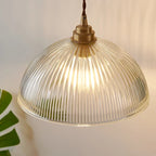Retro-style glass pendant lamp with an embossed shade and brass finish
