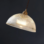 Retro-style glass pendant lamp with an embossed shade and brass finish
