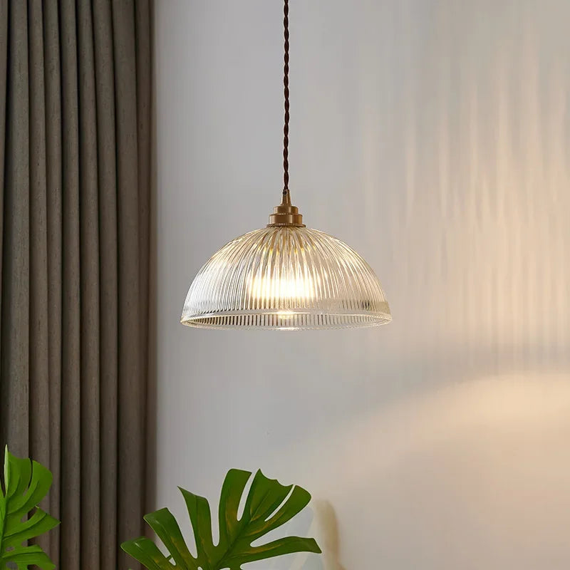 Retro-style glass pendant lamp with an embossed shade and brass finish
